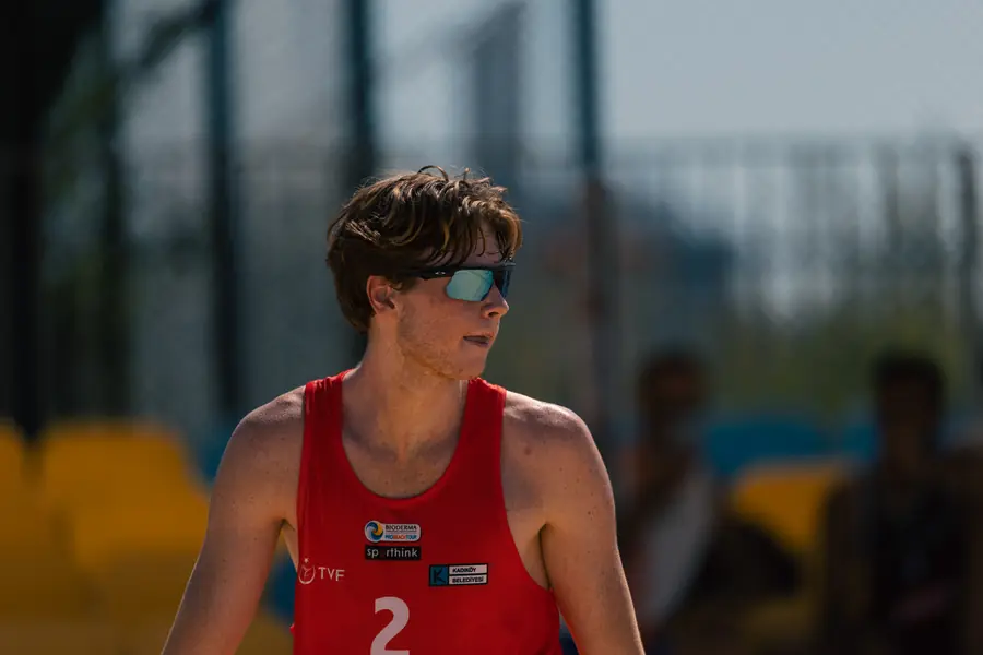 Young male player in a red jersey, number 2, in soft focus light