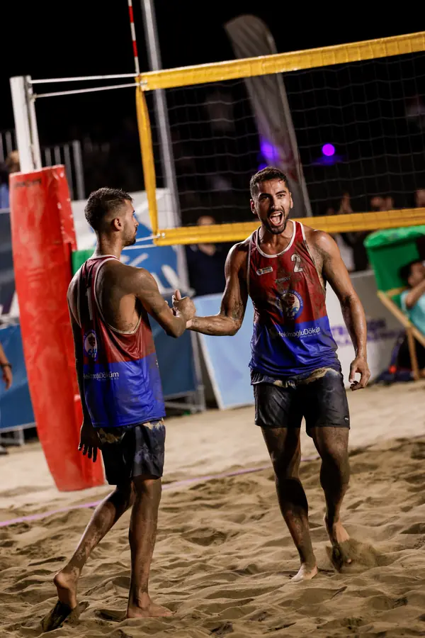 Two players high-five under night lights
