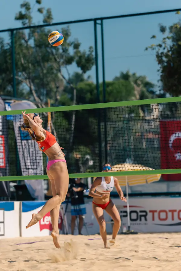 Female player rises to attack, sand flying